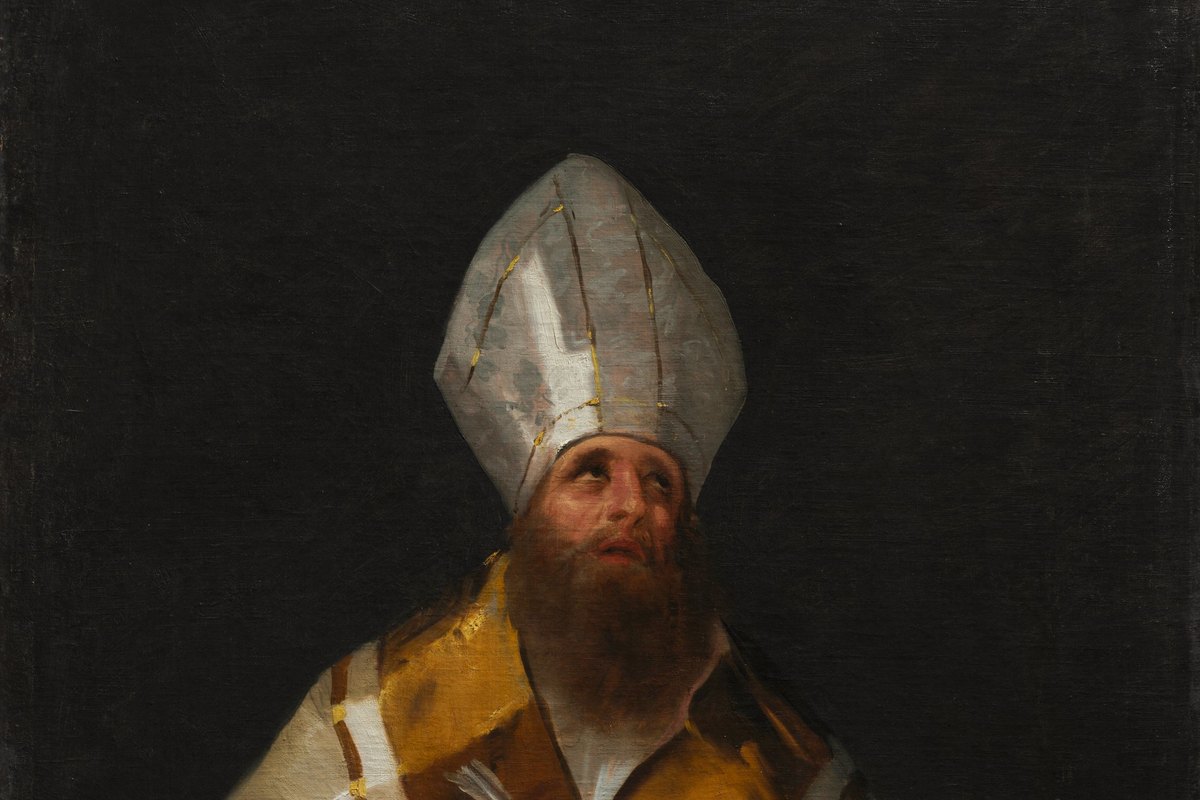 Saint Ambrose in a white mitre and golden cope, looking upward from an open book.